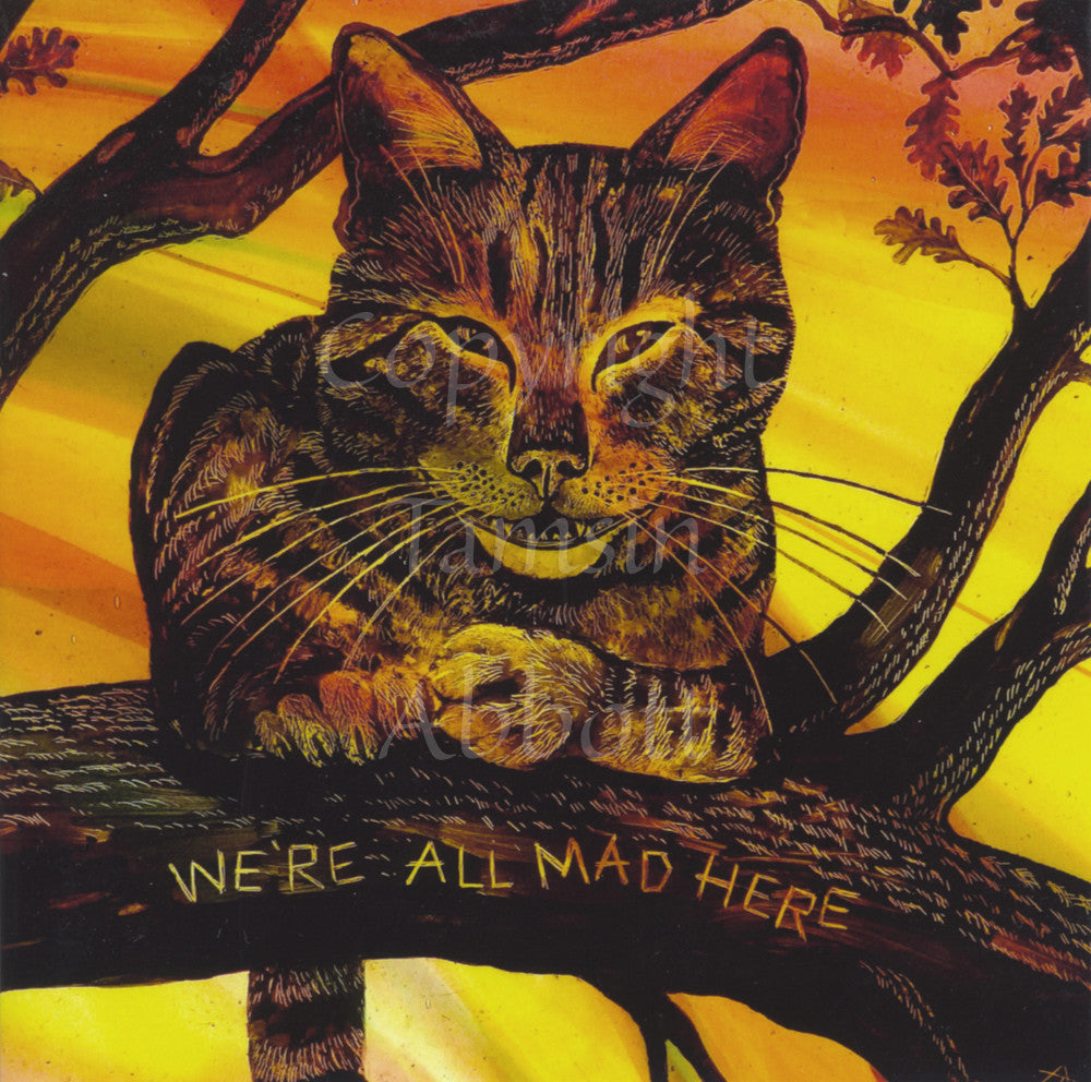 A tabby cat with a wide, toothy grin sits on a branch facing the viewer, front paws curled in front of his chest, tail hanging down behind. Smaller branches, some with oak leaves, grow out from the main branch. The words "We're all mad here" are engraved into the branch under the cat. The design is cast in oranges and yellows.