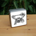 Black and white pencil drawing of a fluffy grey spider holding an ornate key above their head with their two front legs. The appearance and posture is furry and friendly, and not intended to be scary.