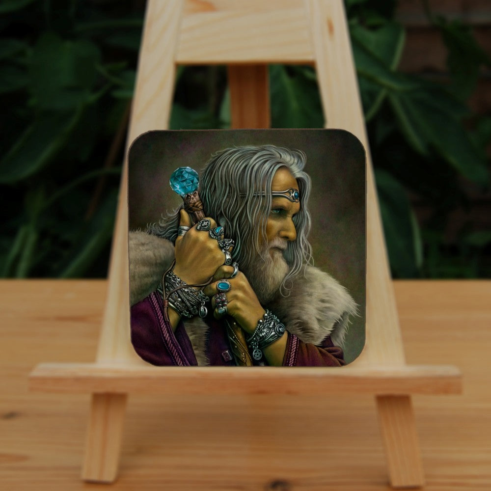 A man with long grey hair and a beard leans on his staff, looking intently to the right. He is wearing a deep purple coat with a pale-coloured fur mantle, and many silver bracelets and rings. A silver pentagram can be glimpsed from behind his staff. The top of the wooden staff has a large, turquoise jewel at the top.