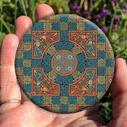 An intricate design incorporating dozens of Celtic knots. Colours are orange, beige and blue.