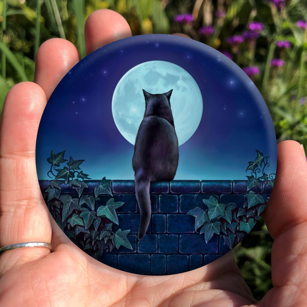 A black cat sitting on a brick wall at night looking towards the full moon. There is ivy on the wall either side of the cat. Colours are mostly deep blues and greens.