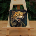A square coaster: The head and body of a snarling brown striped cat.