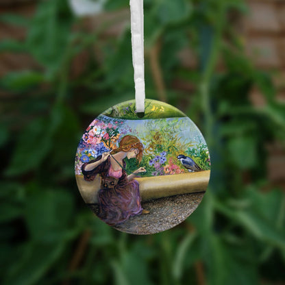 The reverse side of the ornament showing just the lady sitting with a large needle and thread in hand.