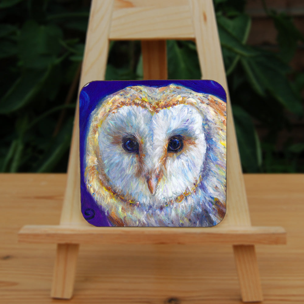 The head of a barn owl, looking directly at the viewer. The background is deep blue.