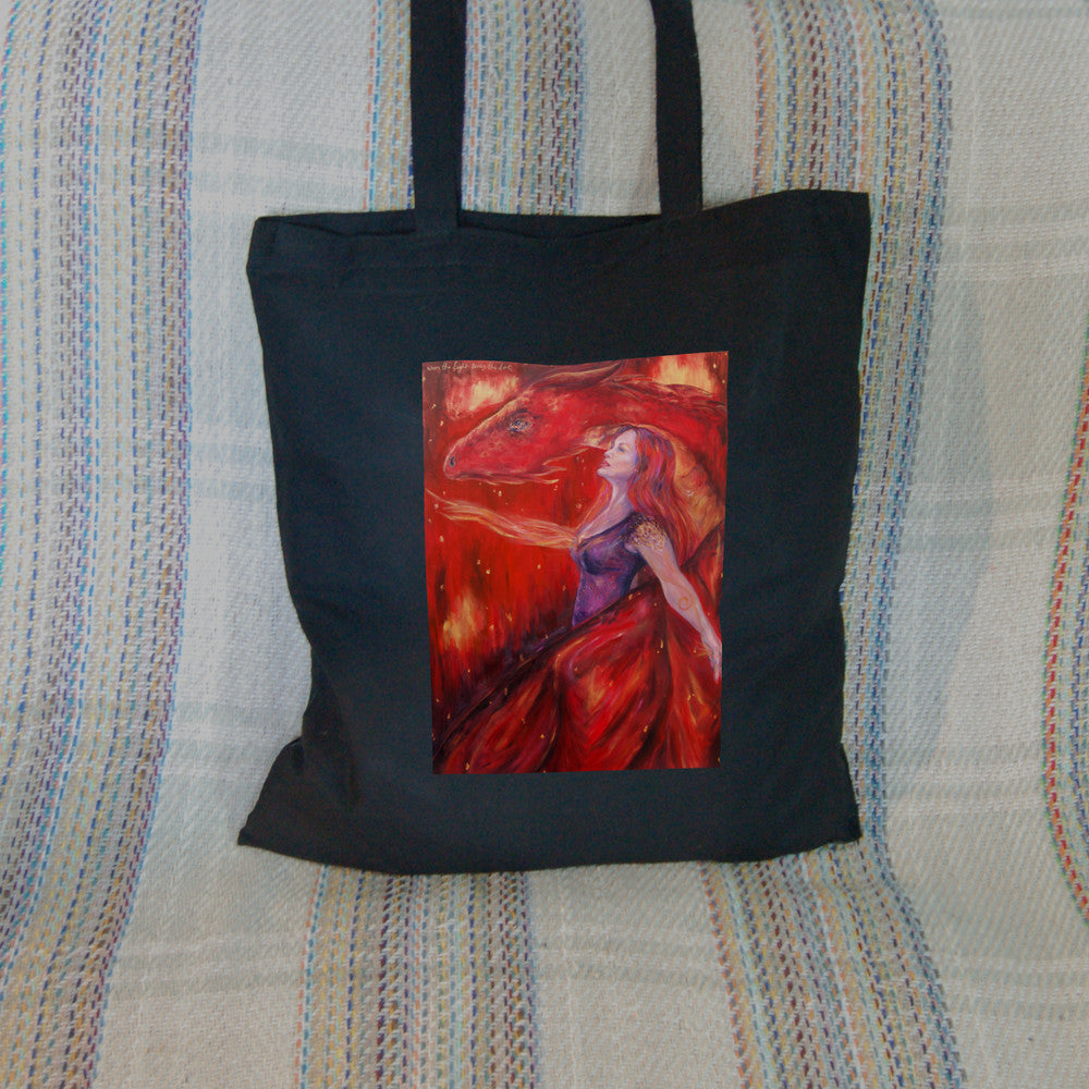 A woman with long red hair and wearing a sleeveless purple dress stands in front of a red dragon. Both look to the left. A wing wraps around one side, with the head on the other. A stream of fire is emitting from the location of the woman's heart. The overall design colour is red.