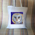 The head of a barn owl, looking directly at the viewer. The background is deep blue.