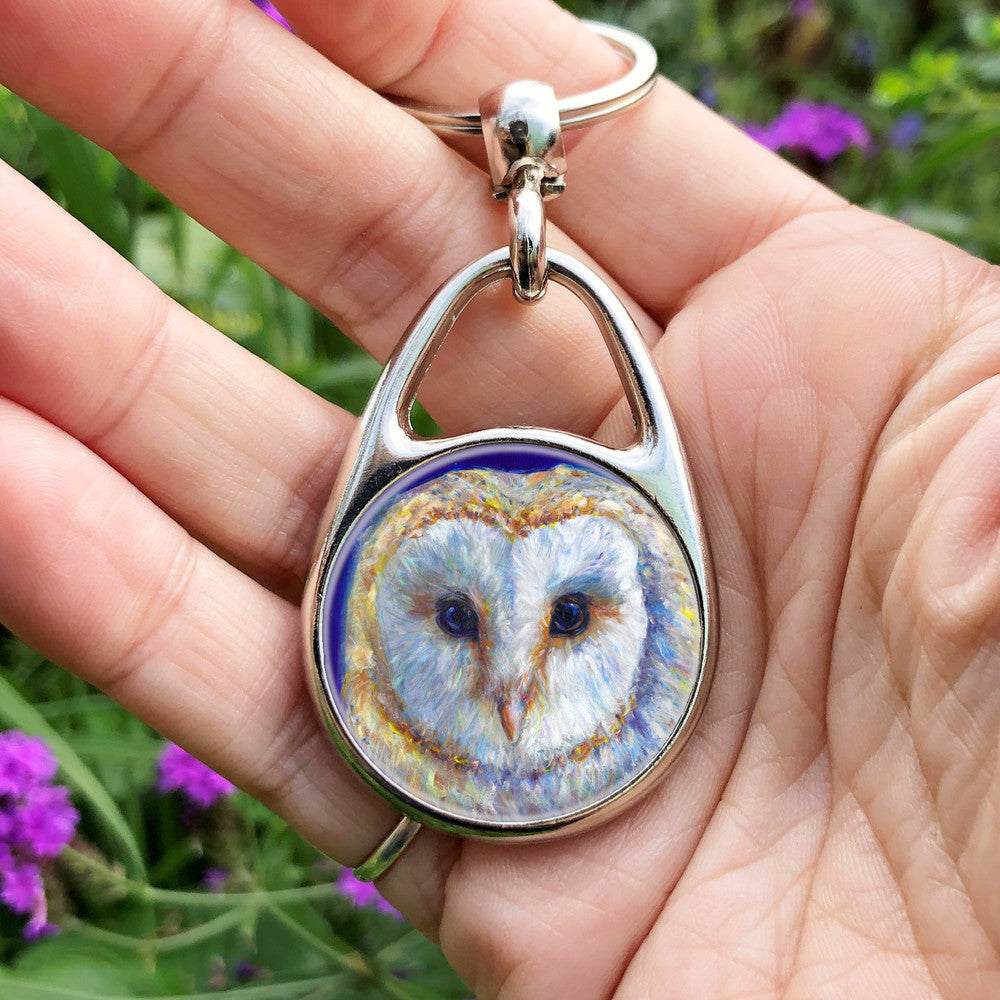 The head of a barn owl, looking directly at the viewer. The background is deep blue.