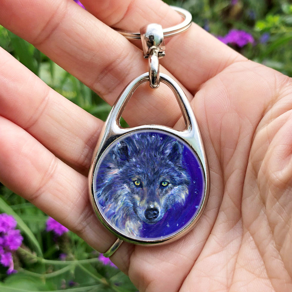 The head of a wolf, looking directly at the viewer. The overall colour of both the wolf and the background are shades of blue, with the exception of yellow/green eyes and flashes of paler fur around the neck.