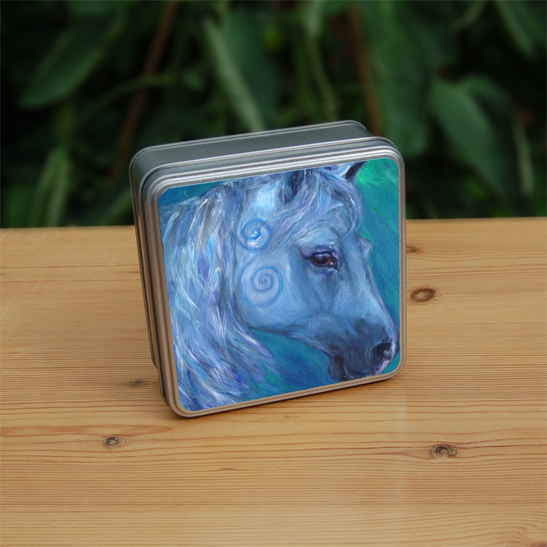 The head and mane of a horse, head facing mostly to the right. The horse is painted entirely in blue apart from a deep brown eye, with two spirals on and above the cheek. The background is blue-green.