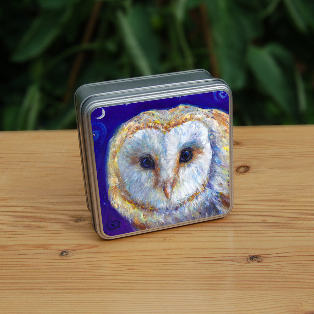 The head of a barn owl, looking directly at the viewer. The background is deep blue.