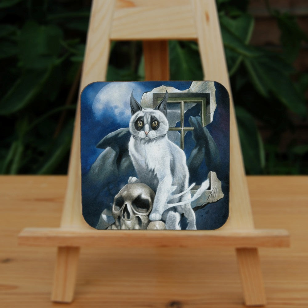 A white cat with black fur around the eyes and black ears sits perched on a skull and looking towards the viewer. In the background is a megalith, a broken window and a full moon rising from behind clouds. Colours are deep blue, grey and light brown.