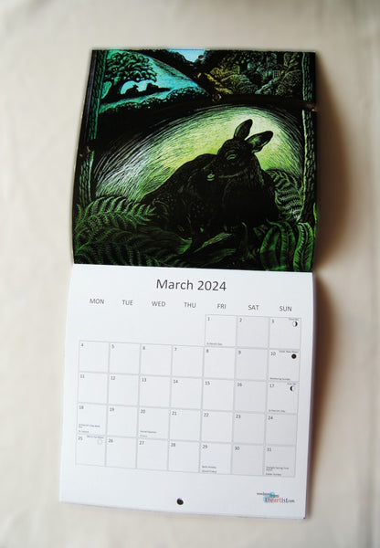 Page for March 2024, featuring a young deer sitting among ferns or bracken. Fields and a house can be seen in the background. The calendar opens up to show the image at the top, with the calendar section below.