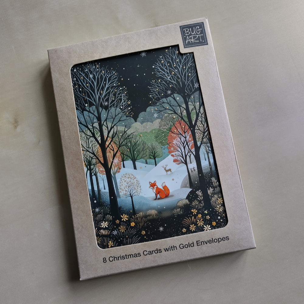 A red fox sits looking toward the viewer in a snow-covered clearing. They are surrounded by the silhouettes of leafless trees in the foreground, red and gold leafy trees behind, with more trees beyond. They reach up toward a dark, starlit sky. A stag stands in the snow far behind the fox, and a robin perches in one of the trees. In the foreground, a carpet of gold flowers and pale leaves.