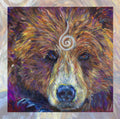 The head of a bear looking directly at the viewer. A pale-coloured spiral is coiled at their forehead, opening upwards. Their fur is a mixture of reds, golds and browns, with a pale snout.