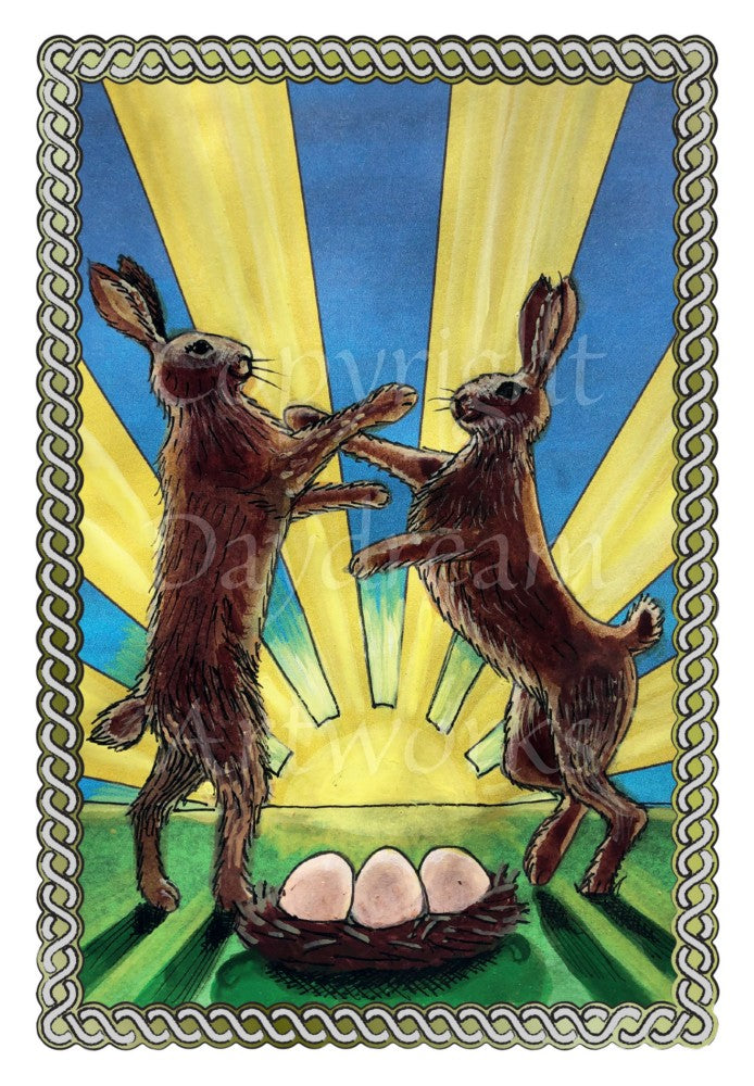 Two brown hares stand in a field on their hind legs, boxing. A nest containing three eggs stands at their feet. Behind them, the sun radiates light up and outwards against a deep blue sky. A twisted rope border surrounds the design.
