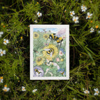 Greeting card featuring bees and flowers on a grassy background