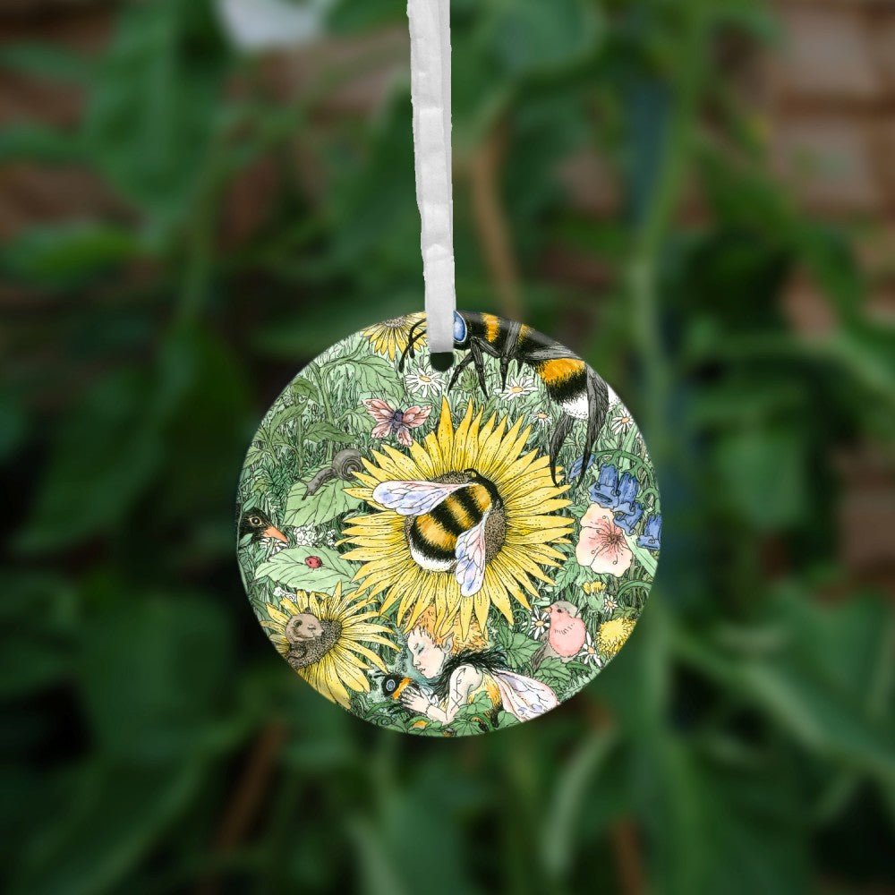 A meadow of green foliage and yellow, blue, pink and purple flowers rises towards a blue sky in the distance. A bee descends towards a central yellow flower. Another bee is already sitting in the middle of it. At the bottom, a fairy with orange hair and bee-coloured dress sleeps while holding a bee. Birds, mice and insects including butterflies are scattered throughout.