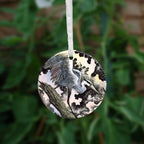 The second side of the ornament. A heron lands on a tilted, broken tree trunk.