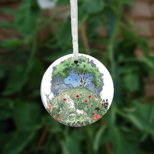 One side of the ornament. At the top there's a tree in full leaf, surrounded by clouds, but clearing to blue in the centre, and swifts wheeling all around. Beneath, the top half of the oval is a flower-filled meadow. A stag and badger stand either side, and a hare, blackbird, mouse, and other creatures are nestled within. The head and shoulders of a young woman lying on her back rise from the ground. 