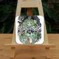 In the upper half of the design, the face of an older woman is surrounded by oak and ivy leaves, an owl, hedgehog butterfly, dragonfly, hare and birds. A labyrinth symbol sits above, and a crescent moon below. In the lower half, the figure of a young girl lies sleeping, surrounded by leaves, bluebells, and unopened ferns. Two mice sit in on a branch above her.