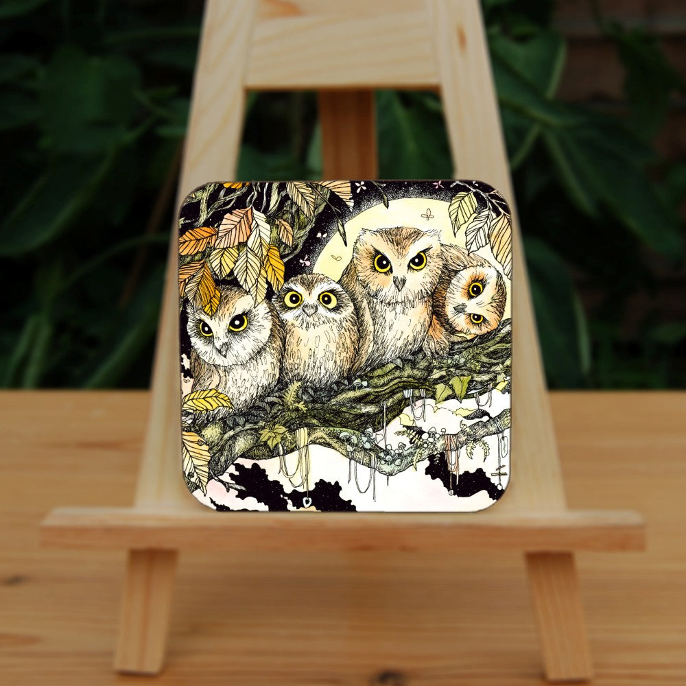 Four owls sit on the branch of a tree looking towards the viewer. One owl at the end has his head tilted sideways. Brown leaves splay down from above and a full moon shines behind them. Clouties and other offerings are wrapped around a branch below them.