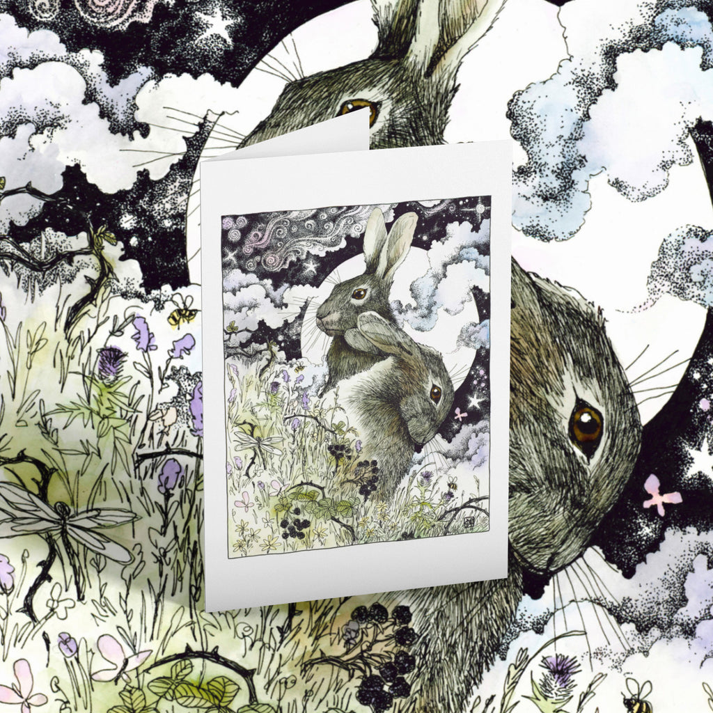 Greeting card of two hares with flowers and butterflies on a matching background.