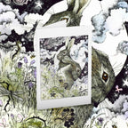 Greeting card of two hares with flowers and butterflies on a matching background.