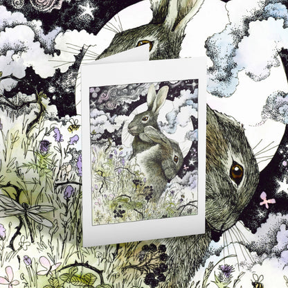 Greeting card of two hares with flowers and butterflies on a matching background.