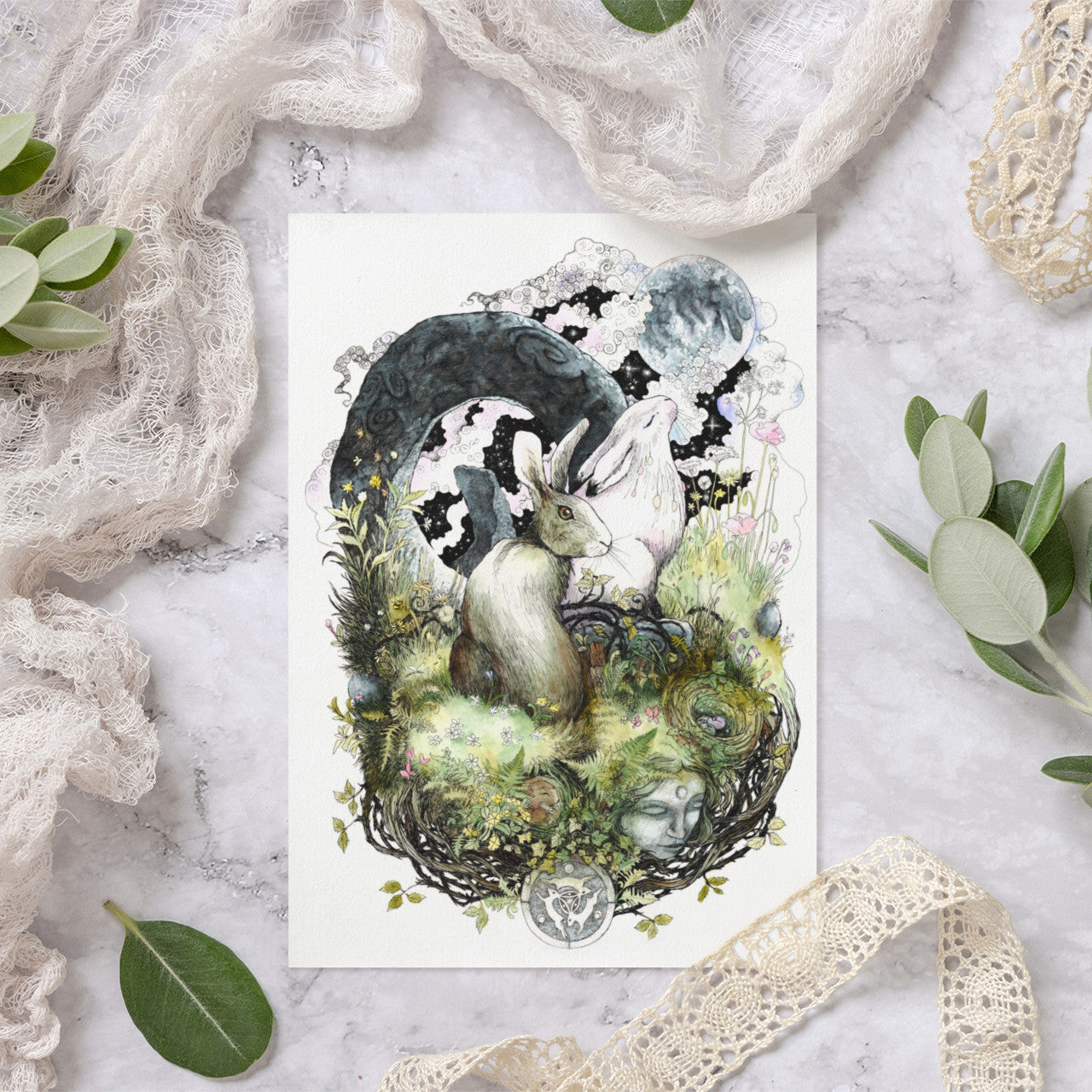 Nature-themed greeting card with hares on a textured surface with greenery