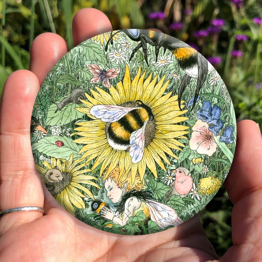 A meadow of green foliage and yellow, blue, pink and purple flowers rises towards a blue sky in the distance. A bee descends towards a central yellow flower. Another bee is already sitting in the middle of it. At the bottom, a fairy with orange hair and bee-coloured dress sleeps while holding a bee. Birds, mice and insects including butterflies are scattered throughout.