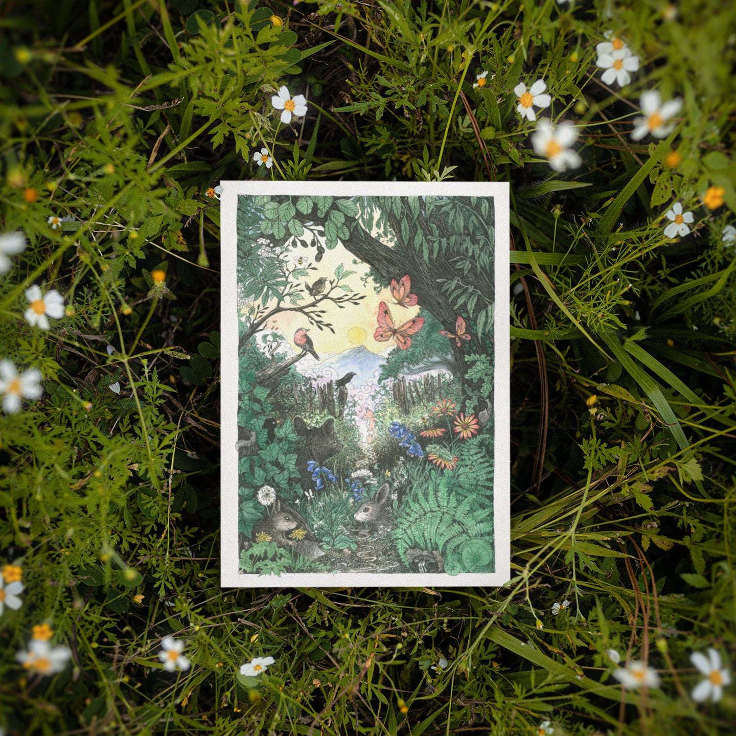 Illustrated card with a forest scene surrounded by greenery and flowers