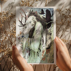 Person holding a card with an illustration of a man with animal features and nature elements.