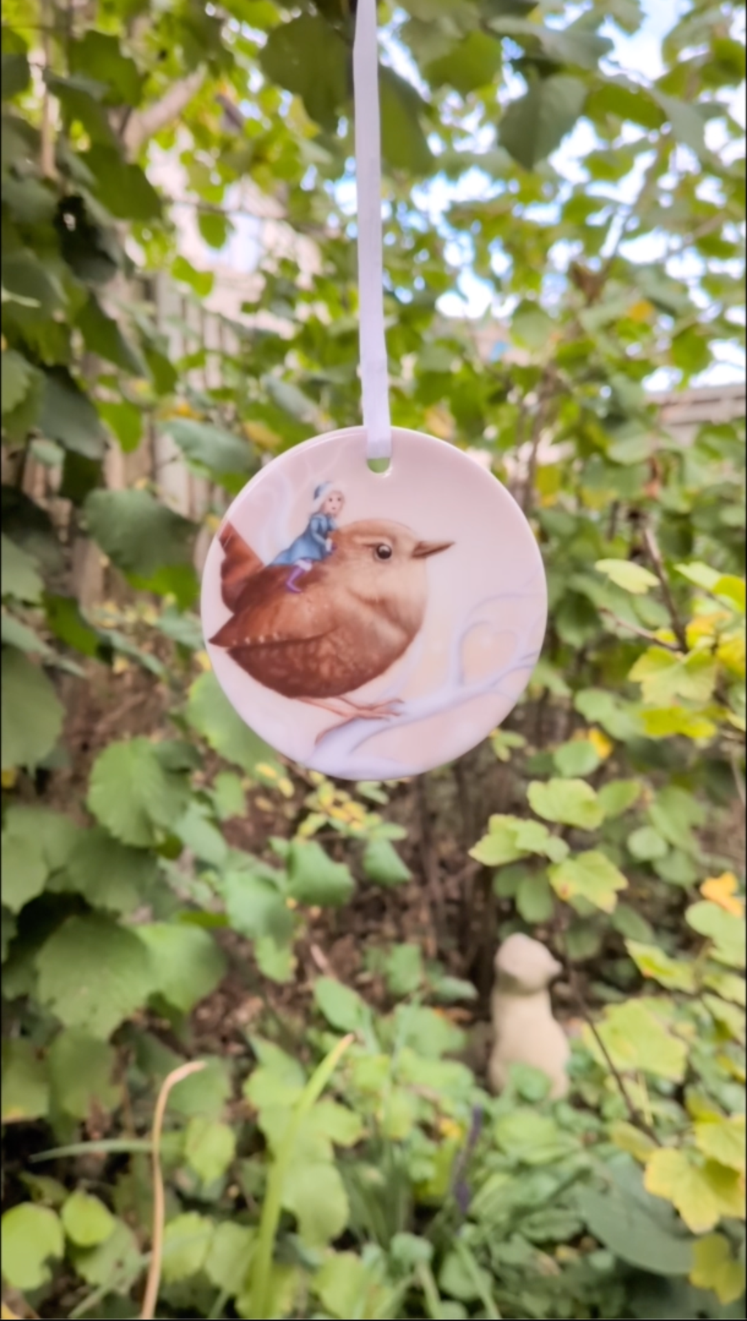 Video of ornament rotating against a leafy background.