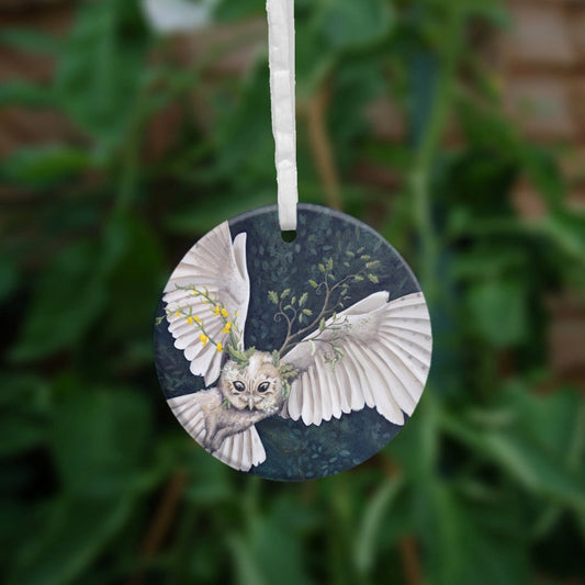 A white owl fills this painting as it flies from the bottom left towards top right. Stems of Meadowsweet with its yellow flowers sprout from the left side of her head, a young oak branch from the right.