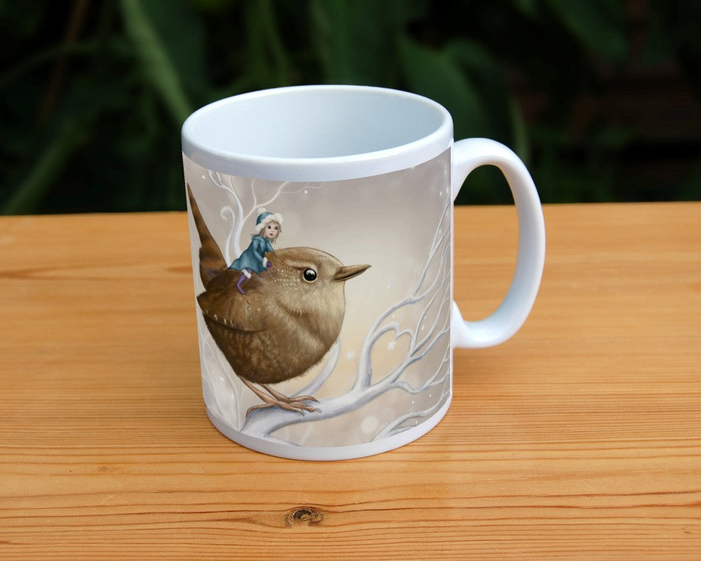 A smiling fairy in a mid-blue coat and hat and purple boots sits on the back of a wren. The wren sits on a white branch. Apart from the fairy, colours are browns and whites.