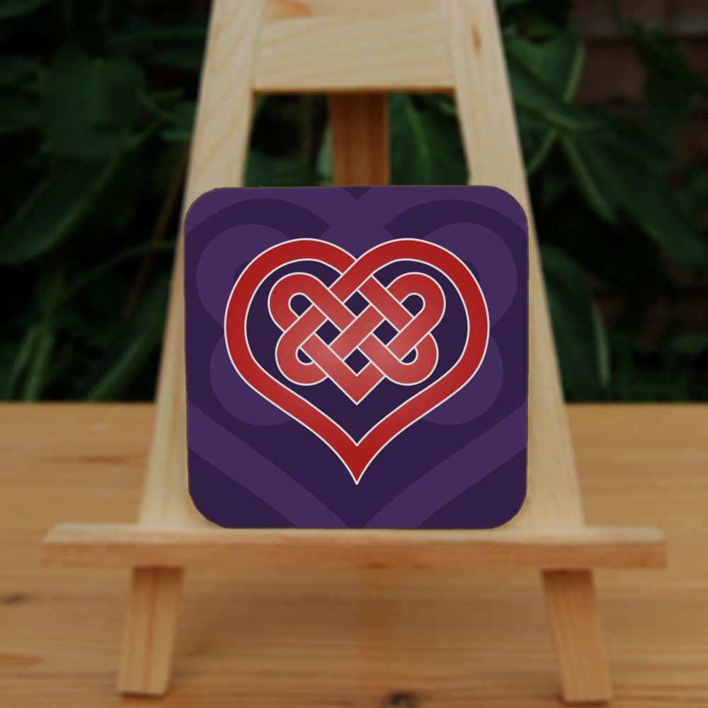 A heart shape which forms into a Celtic knot from the top and into the centre of the heart. The design is red with a white edge. The background is purple.