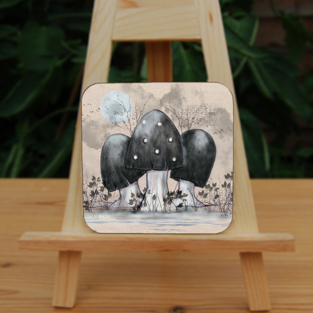 A cluster of toadstools with black caps. The cap of the centre toadstool has white spots. They're surrounded by the silhouettes of leafy plants, and a mist lies low on the ground. Above them a silvery full moon shines, and a flock of birds flies across. The background is a mottled beige.